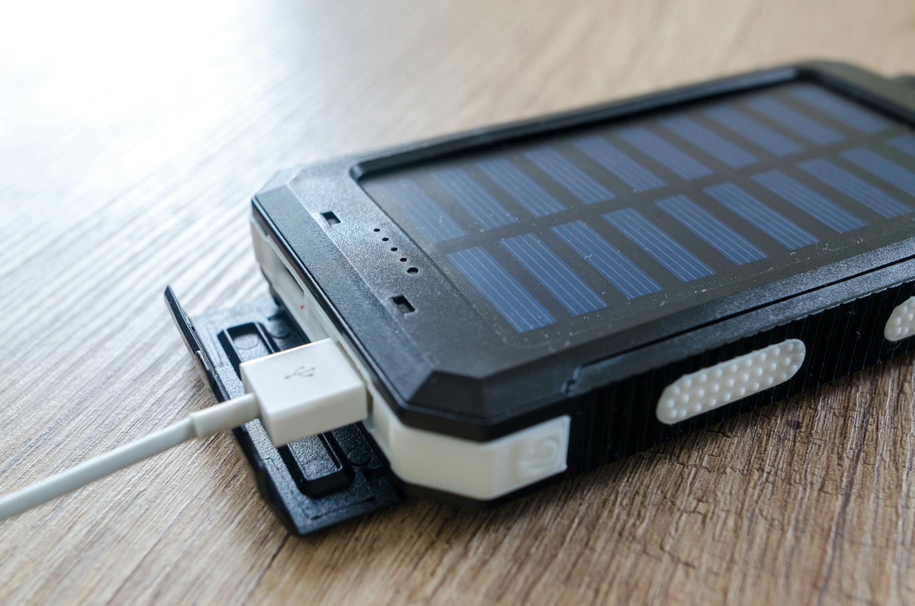 Zbliżenie na ładowarkę solarną z portem USB na drewnianym blacie