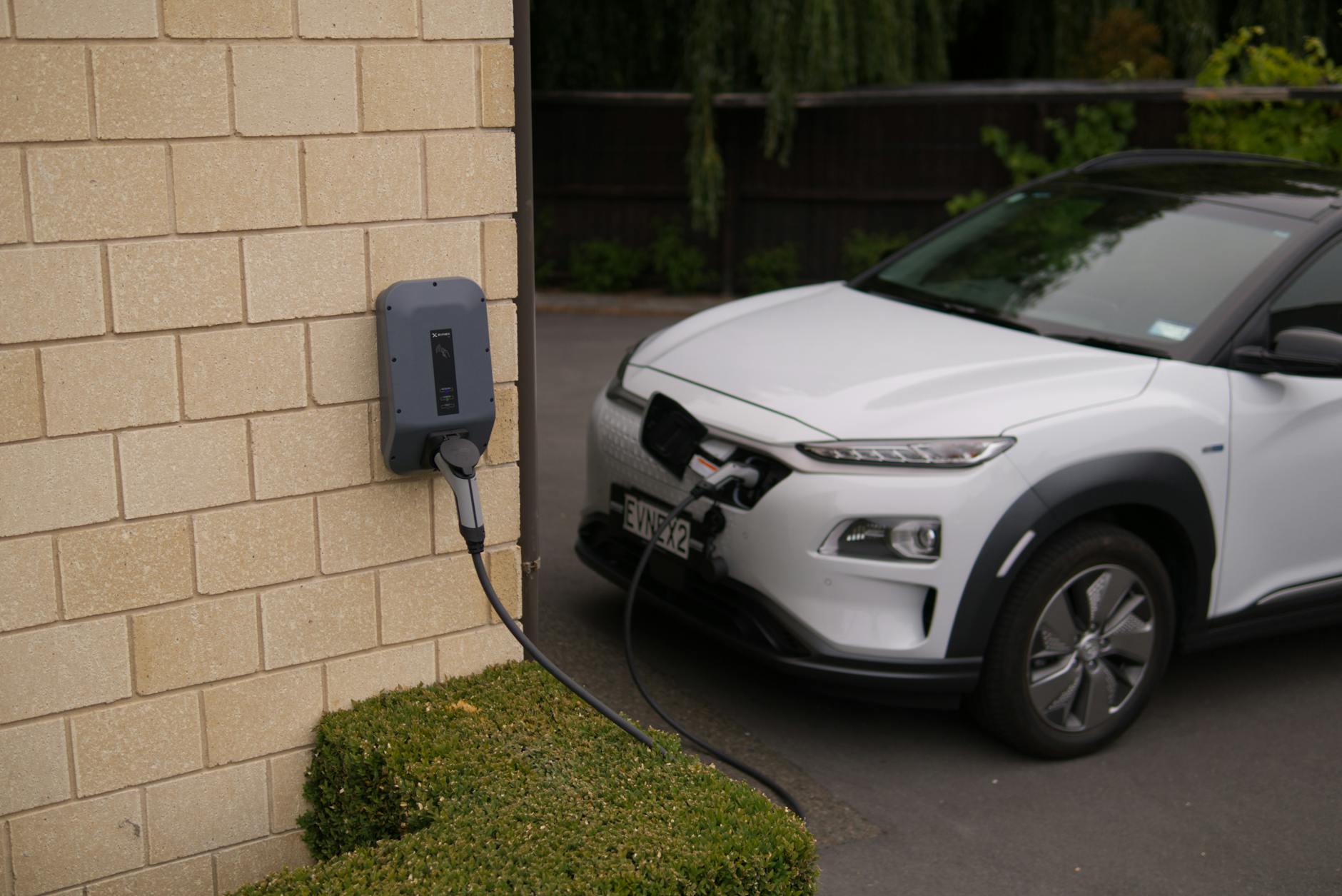 Biały samochód elektryczny ładowany na stacji w Christchurch