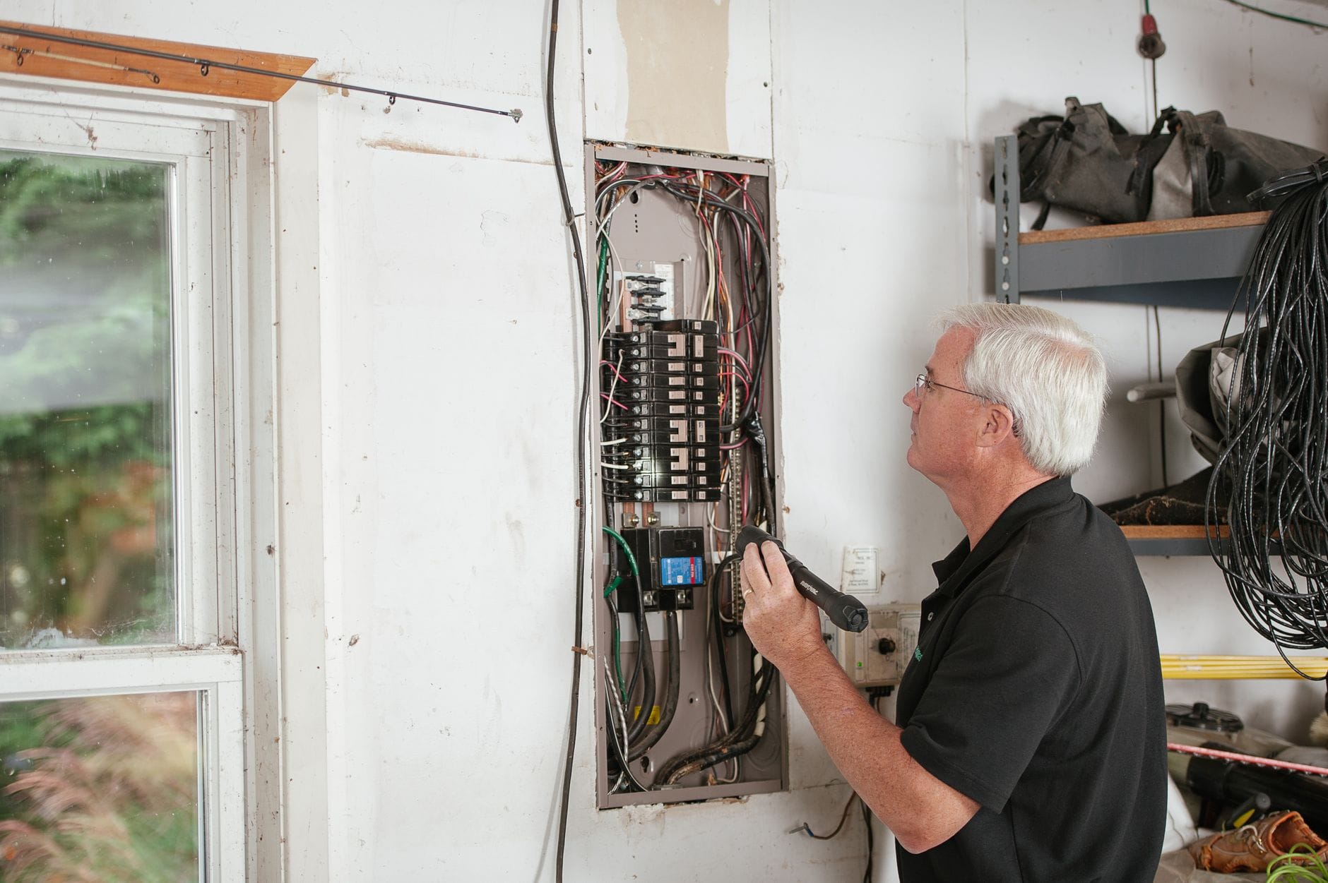 Elektryk sprawdza domową rozdzielnicę podczas projektowania instalacji PV